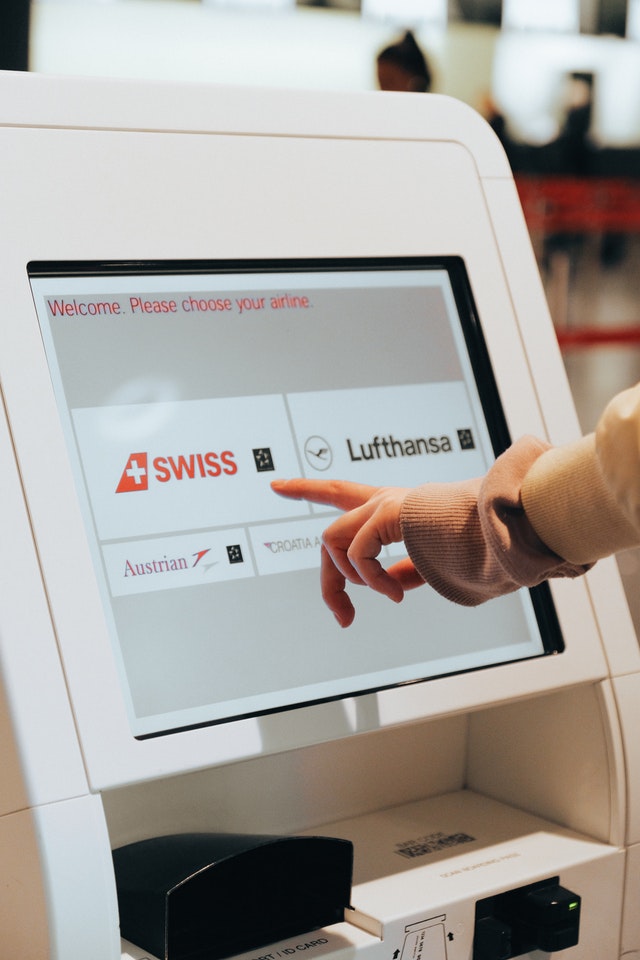 image of a person using a self-serve touchscreen display kiosk